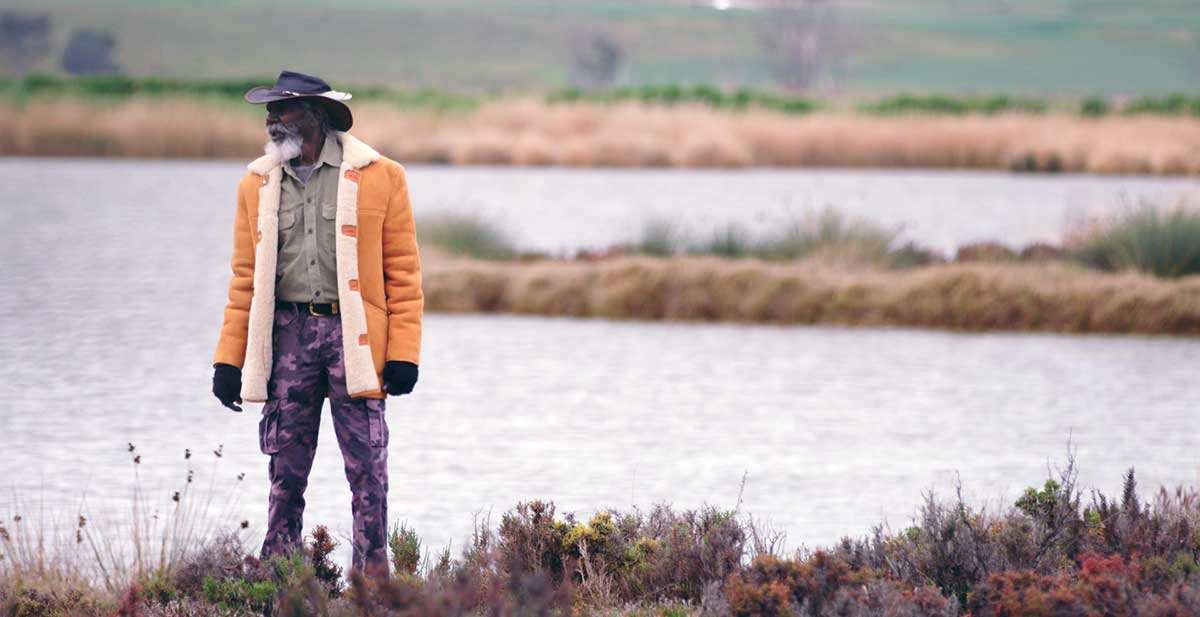 david-gulpilil-orange-jacket-lakeside