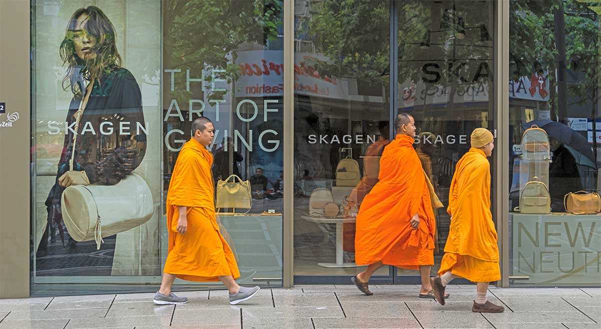 monks walk past shop window buddhism